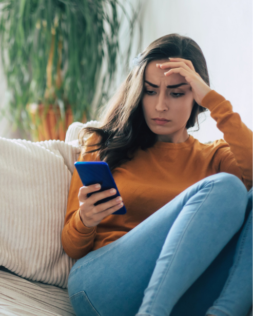 wife reading questions and answers on her phone, sitting on a couch