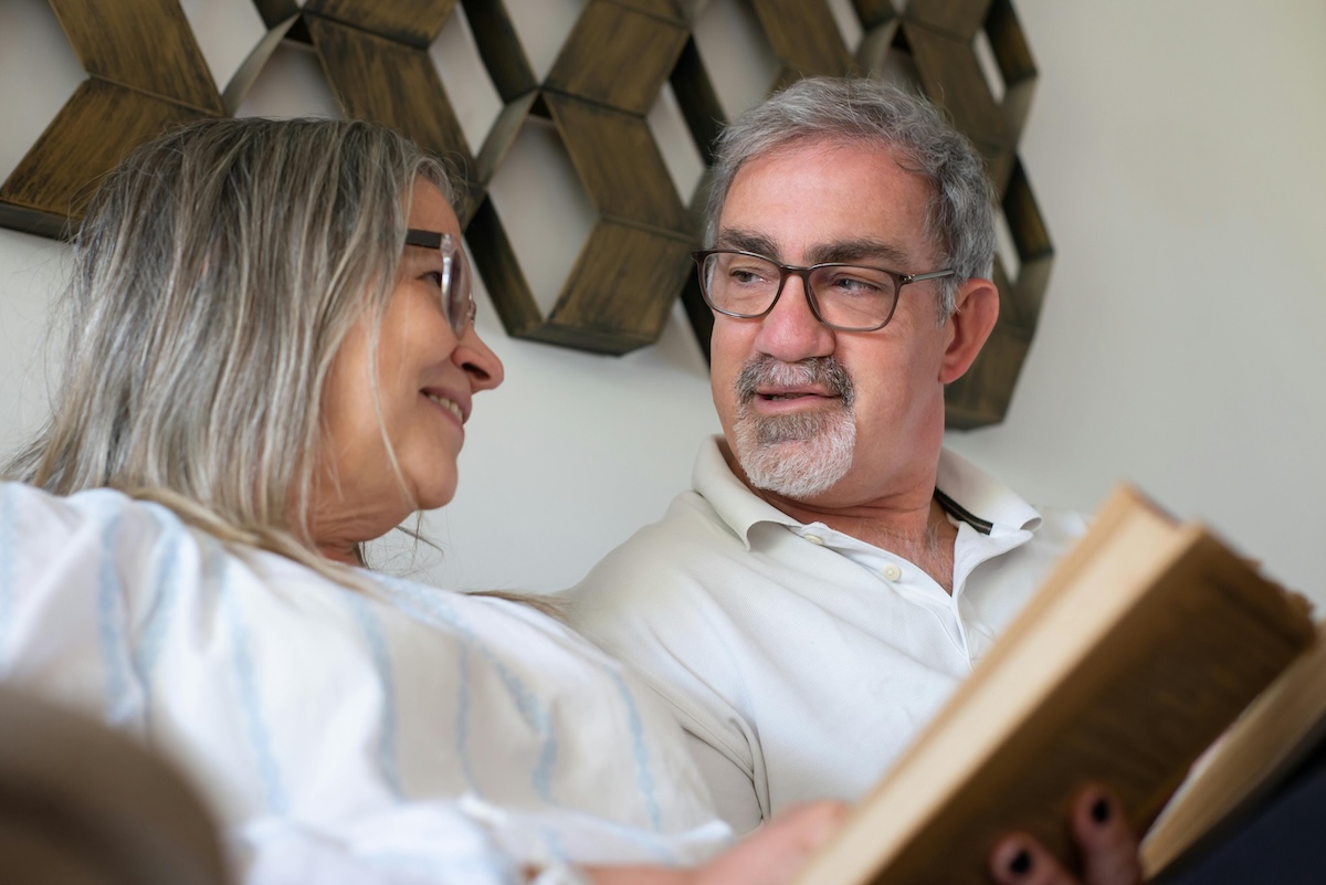 A smiling couple enjoys a positive, connected conversation at home, demonstrating the healthy communication that comes from setting loving boundaries and understanding each other's fears.