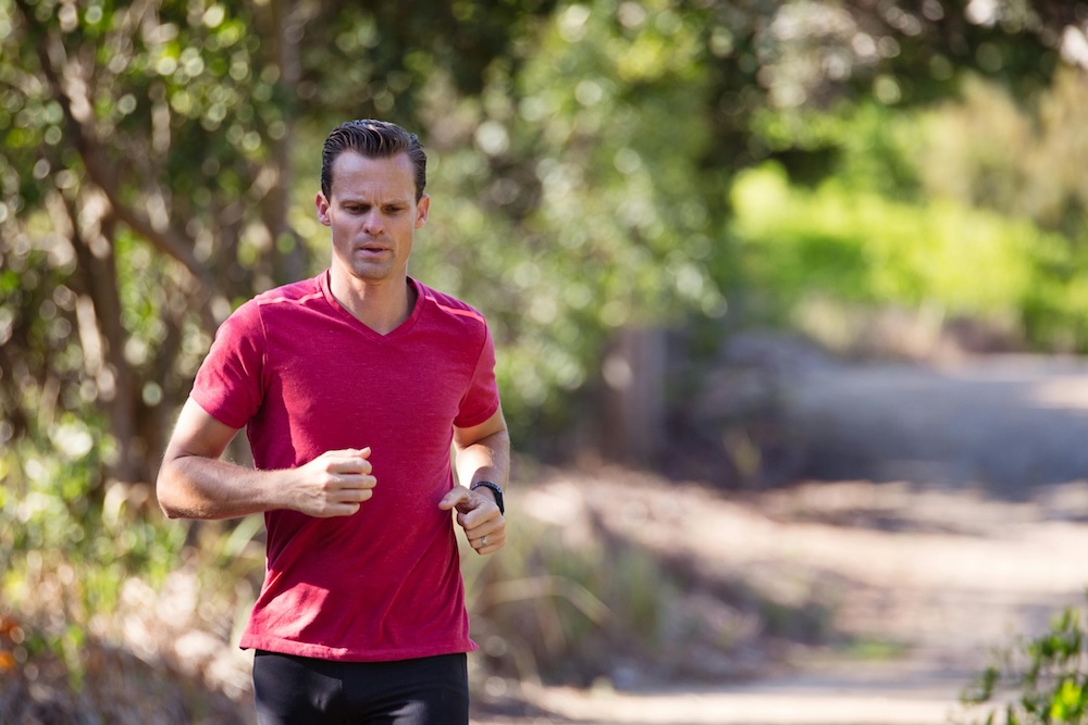 A man jogs through a lush forest trail in Estevan, Saskatchewan, representing healthy coping mechanisms and lifestyle changes as part of pornography addiction recovery.