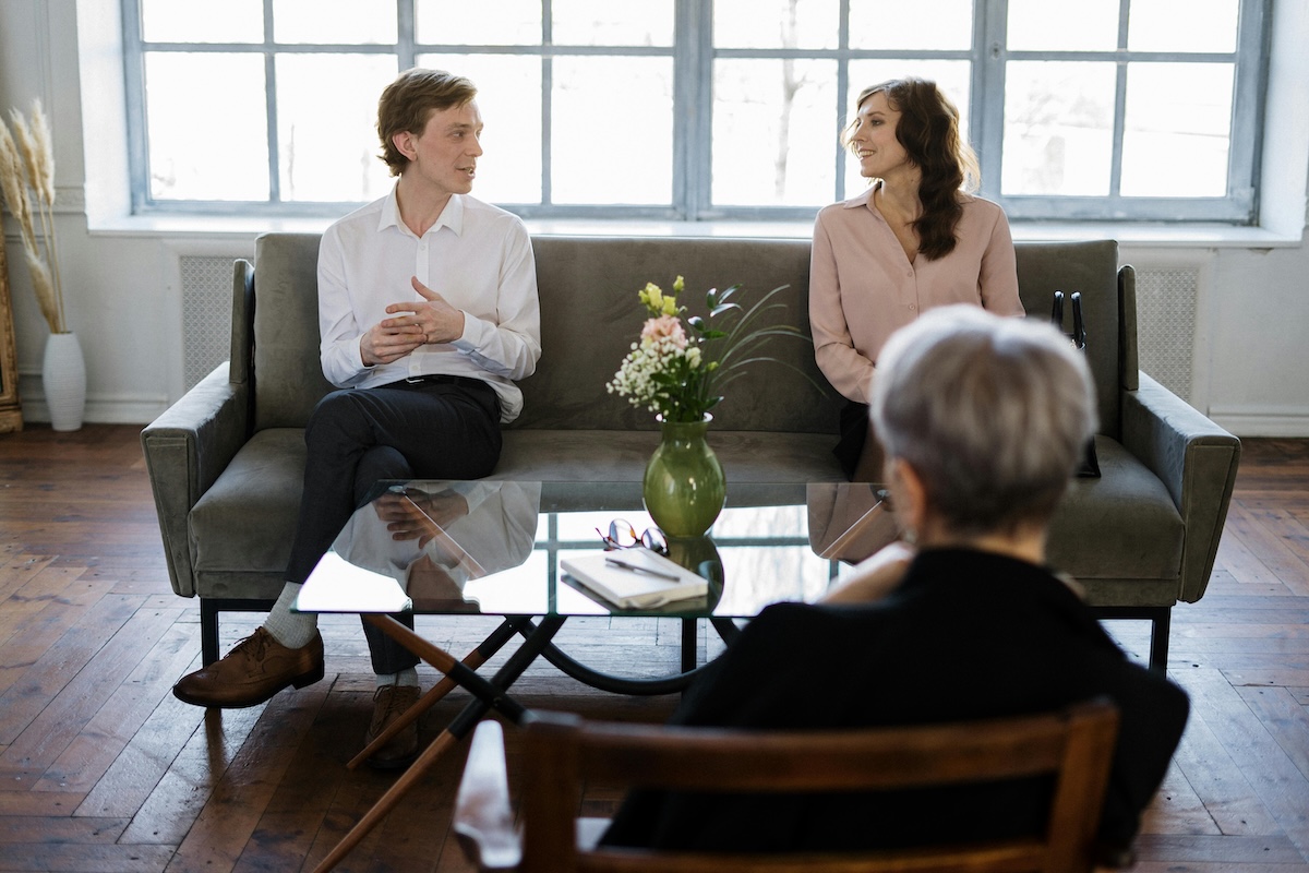 A husband listens with empathy as his wife shares her feelings during an online couples therapy session, a key step in overcoming patterns of control.