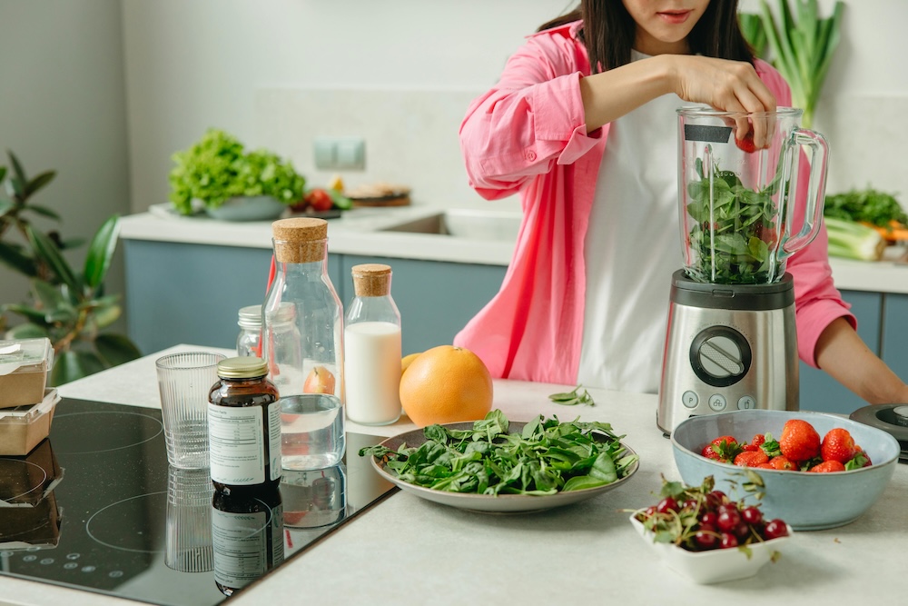 A woman making a healthy smoothie, a visual reminder that practicing self-care, including healthy eating, can help manage the physical and emotional symptoms of pornography withdrawal.