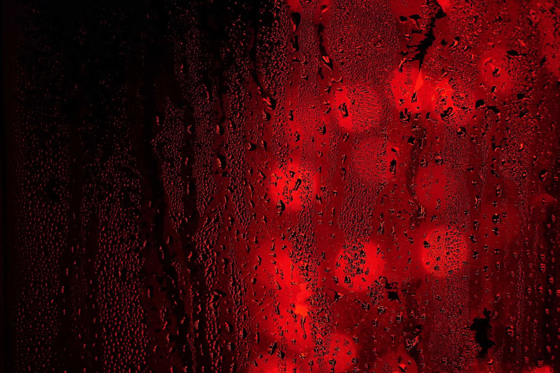 Red lights seen through a rain-streaked window, representing the distorted and painful view of betrayal trauma.