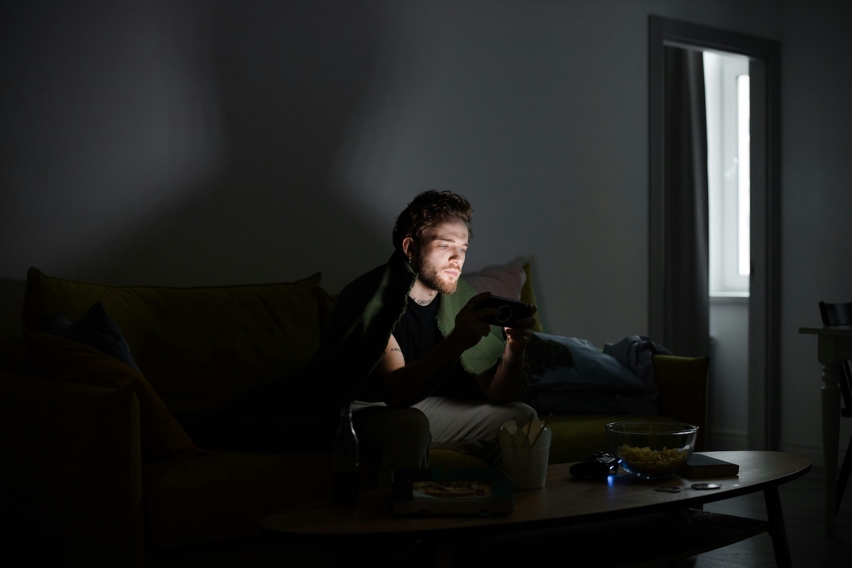 the hidden nature of addiction shown as a man sitting alone in the dark