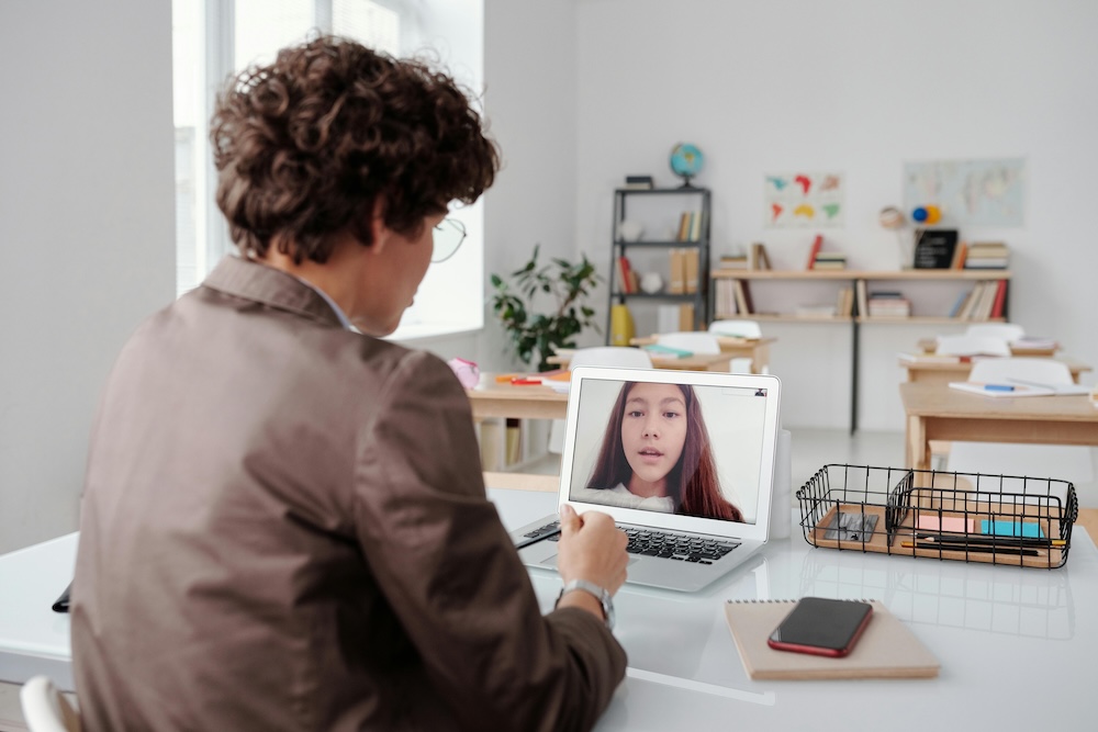 A person engaging in a supportive and compassionate online counseling session with a professional therapist through a laptop.