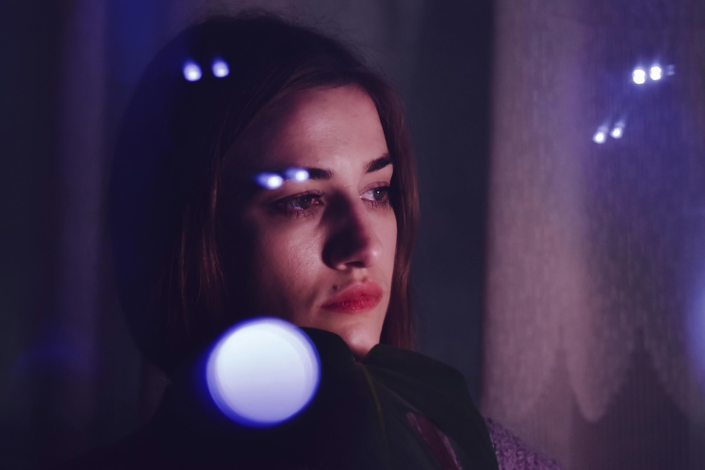 A woman looking out a window into the distance, representing the confusion and disorientation of chronic betrayal trauma.