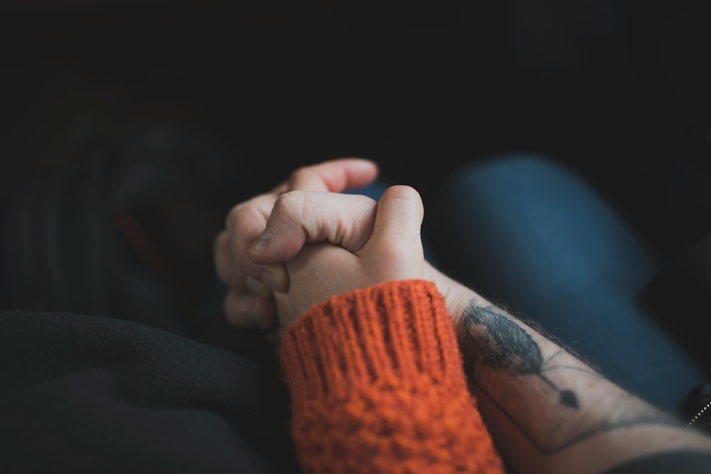 A close-up of a couple’s hands gently touching, symbolizing the restoration of emotional safety and connection through EFT.