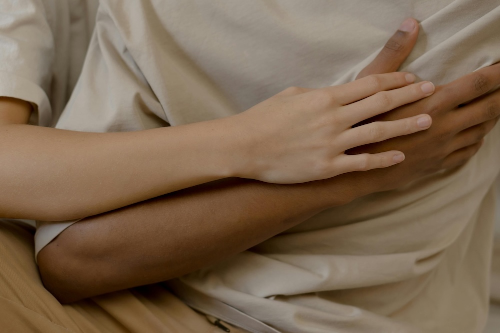 A gentle, non-sexual touch between partners, demonstrating the first steps of Sensate Focus exercises to rebuild physical comfort.