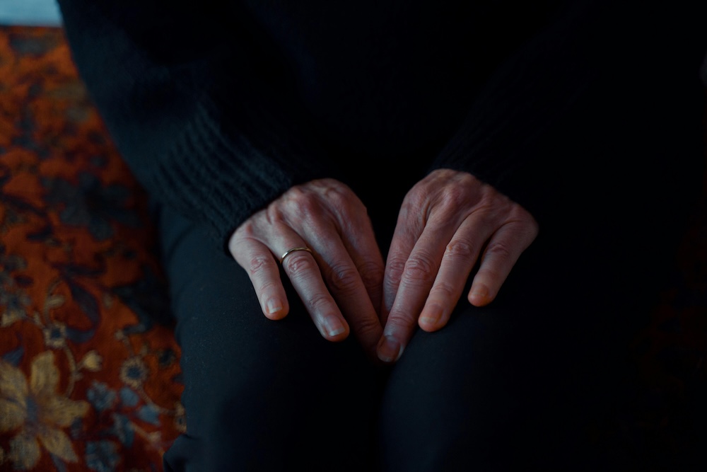 partner sitting with hands in her lap, holding stillness after a trigger