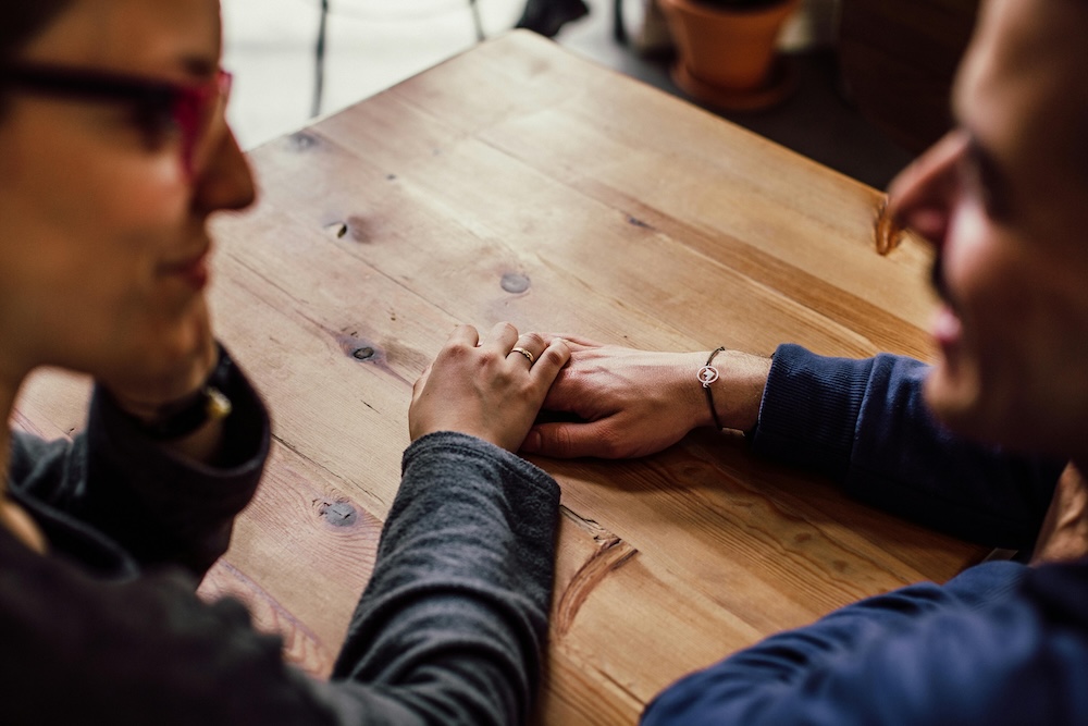 A couple holding hands, symbolizing the hope and healing found through professional couples therapy and intentional redirection.
