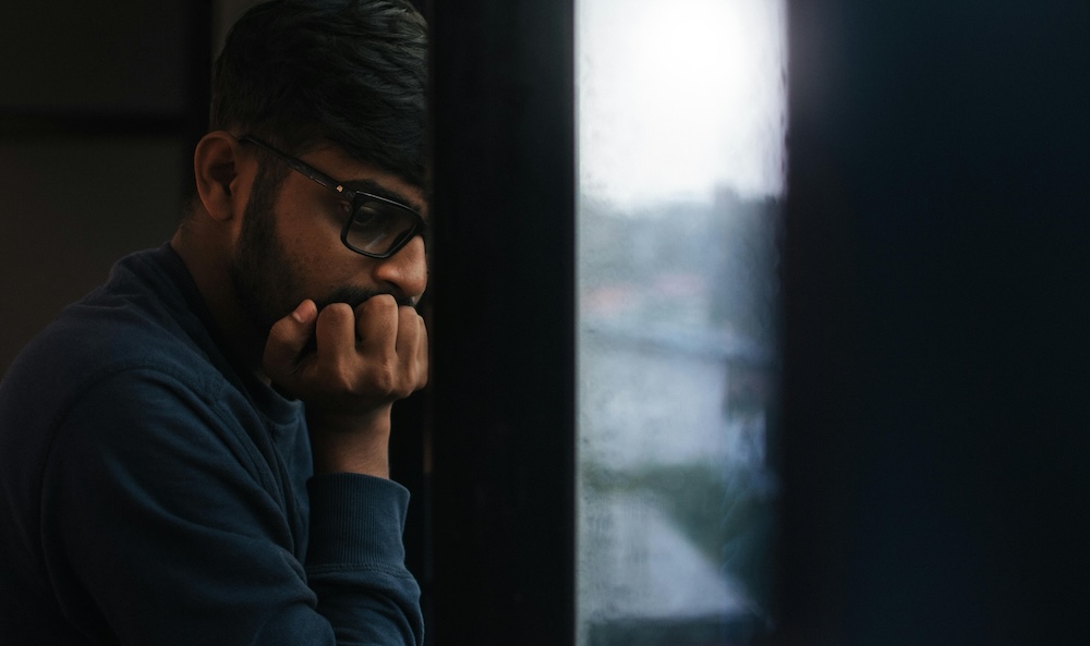 Porn addiction recovery patterns -- person sitting quietly at a window, reflective
