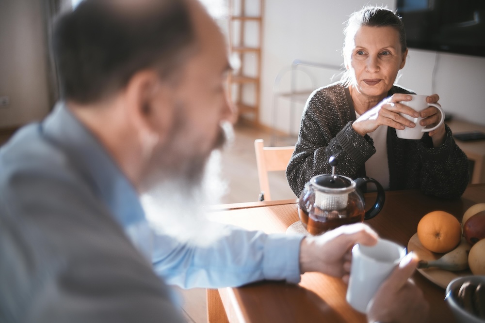 a safe man sits close with his partner in a quiet, attentive conversation
