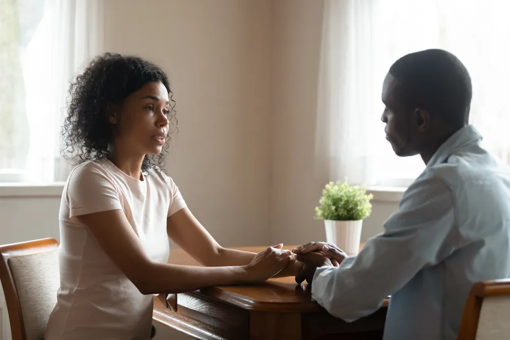 Attachment panic after infidelity: two people's hands close together in a quiet, tense moment