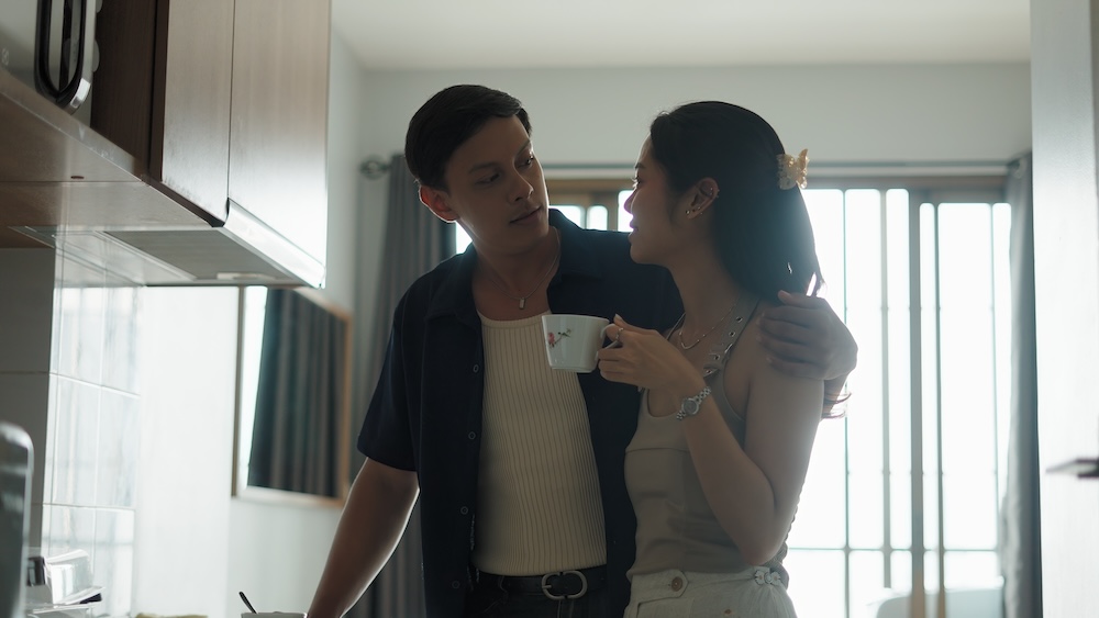 reconnecting after a fight -- two partners standing close in a kitchen, one reaching toward the other