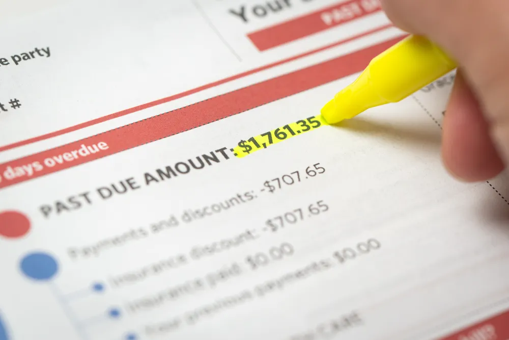A highlighter marks the total amount owed on a statement, one line in the ledger that backs the disclosed number